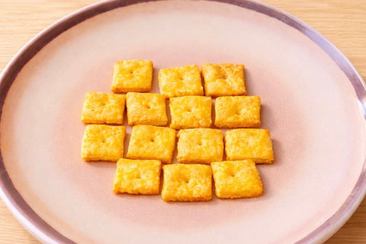 Krokante huisgemaakte kaascrackers met slechts 5 ingrediënten, gemaakt van geraspte belegen kaas en bloem, goudbruin gebakken in vierkantjes.